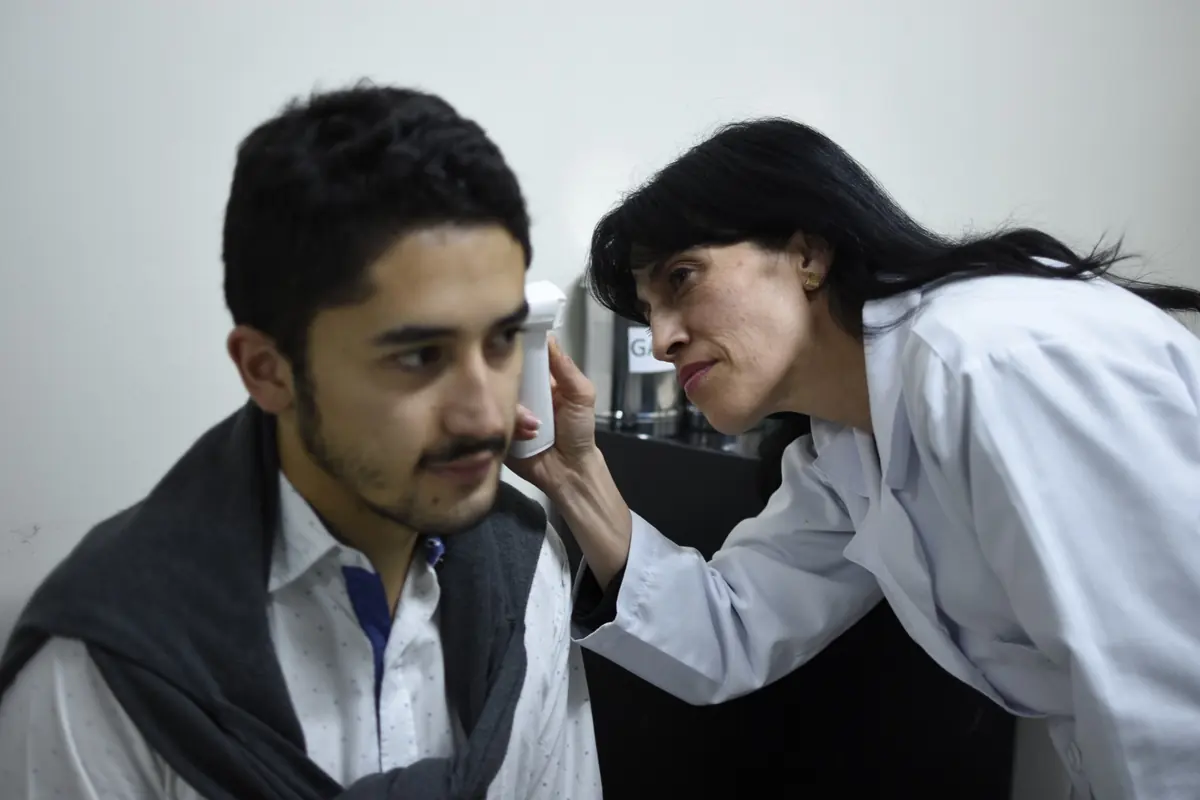 Profesional de la salud de Porvida realizando una valoración auditiva a un paciente
